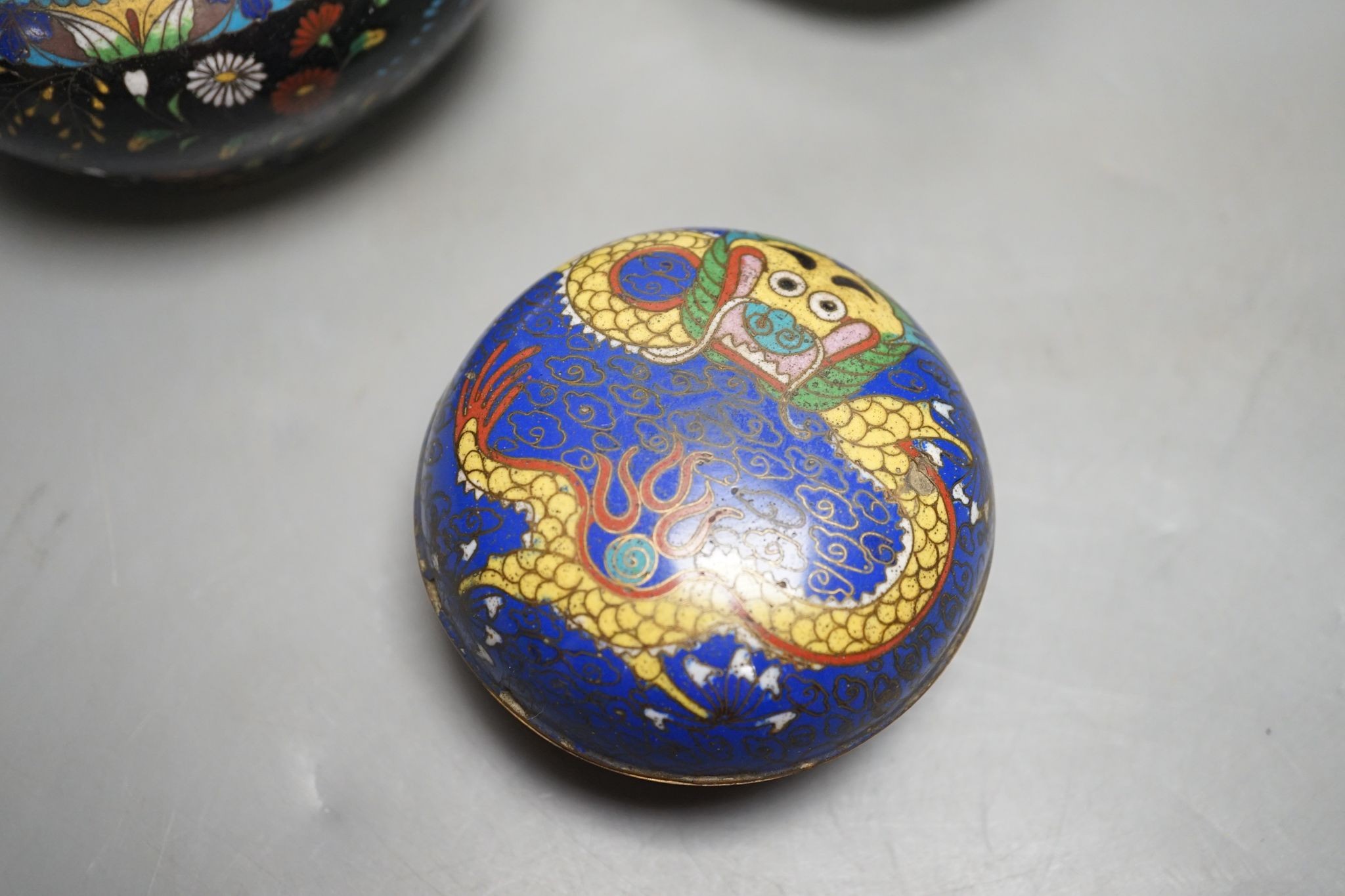 A Chinese cloisonné enamel dragon box and cover and two Japanese cloisonné enamel vessels, tallest 18cm